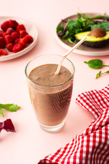 Healthy breakfasts, smoothies made of frozen strawberries, avocado and banana, pea protein and linen seeds, salad leaves, smoothies in a glass with a straw