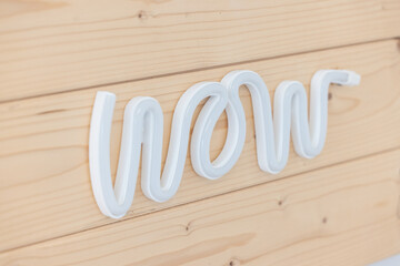 Wandbild WOW! Leuchtschrift "wow" auf Holz, Neon-Buchstaben und helle Holzbretter. Kunst oder Wandbild. Dekoration oder Kunst