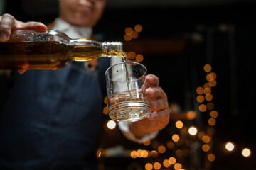 Barman pouring whiskey whiskey glass beautiful night