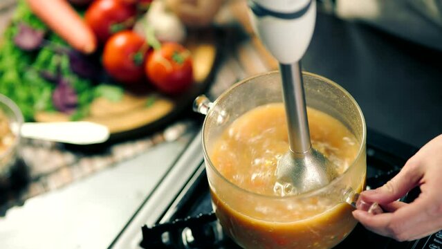 Blending soup with blender in kitchen