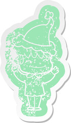 cartoon distressed sticker of a happy boy wearing santa hat