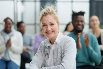 young attractive business woman, teacher or trainer-mentor, looking at the camera