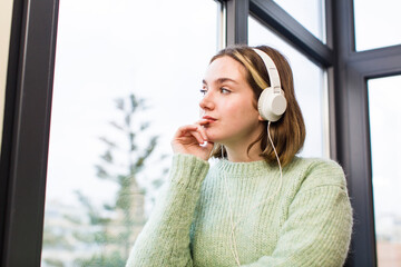 pretty young woman listening music with headphones. house interior design