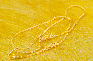 The Gold necklace on gold color background.