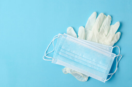 The Disposable medical mask and gloves on a blue background.