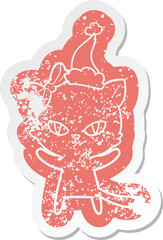 cute cartoon distressed sticker of a cat wearing santa hat