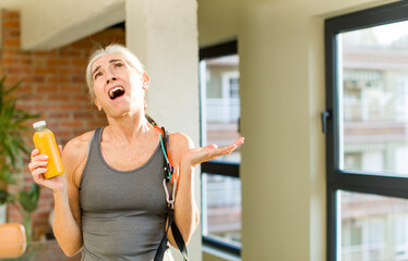 pretty senior woman screaming with hands up in the air. fitness concept