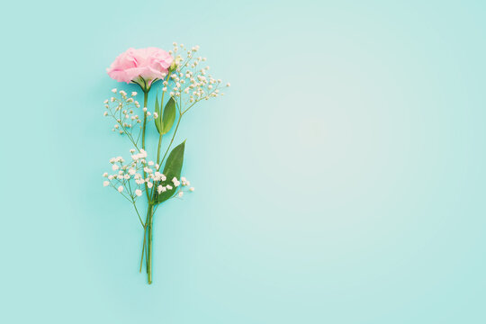 Top view image of delicate lisianthus flowers over pastel blue background