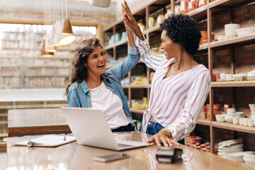 Ceramic shop owners celebrating their success in their store