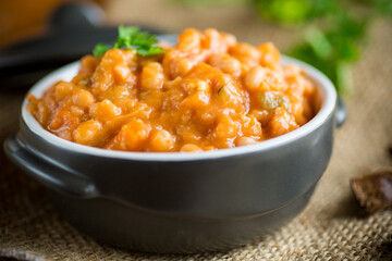 beans stewed with vegetables and spices, in a bowl .