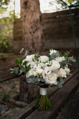 Fototapeta na wymiar Wedding bouquet of white flowers - ranunculus, freesia, lisianthus.. Wedding. Bride and groom.