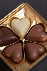 photo 4 pieces of chocolate in the shape of a heart on a black background