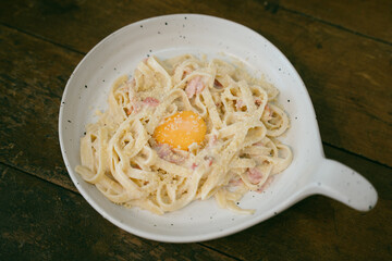 pasta carbonara on a plate with egg yolk and bacon and cheese