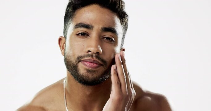 Face, hand and man in studio for skincare, smooth and soft against white background. Touching, relax and portrait of Indian male model satisfied with wellness, beauty and cosmetic care while isolated