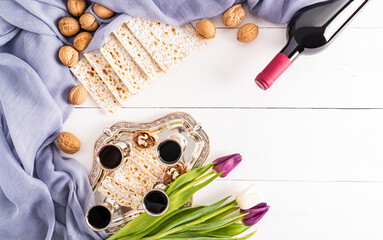silver tray with glasses of red wine, nuts, matzah, flowers .top view. flat lay. a copy space. white background. the concept of the Jewish Passover.