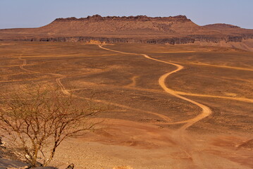 Africa, Mauritania. The southwestern edge of the Sahara Desert. A dirt road in the valley between the Agrotour Mountains, which leads to a fort erected for the filming of a Hollywood feature film.
