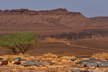 Africa, Mauritania. The southwestern edge of the Sahara Desert. A dirt road in the valley between the Agrotour Mountains, which leads to a fort erected for the filming of a Hollywood feature film.