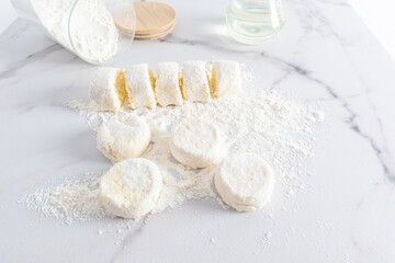 freshly made cottage cheese on a white marble table in flour.