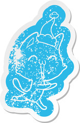 happy cartoon distressed sticker of a cat meowing wearing santa hat