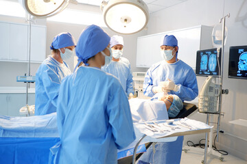 Team of doctors and nurses operating on a patient in the operating room medical concept.