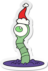sticker cartoon of a alien swamp monster wearing santa hat