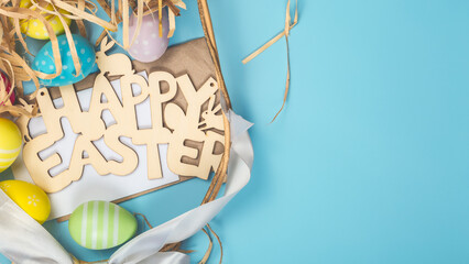 easter holiday card with basket, decorated easter eggs spilled from a basket onto a blue background