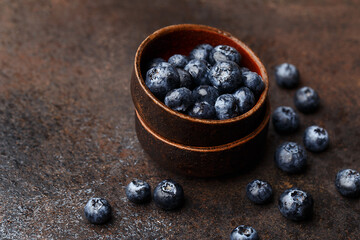 Fresh ripe blueberries with water drops on dark concrete background. Side view, close up, copy space