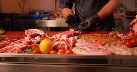 Man placing barbeque preps of square raw meat on skewers. Wooden sticks with pieces of raw meat ready to be grilled.