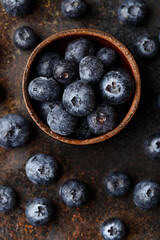 Fresh organic blueberries with water drops on dark concrete background. Top view, close up
