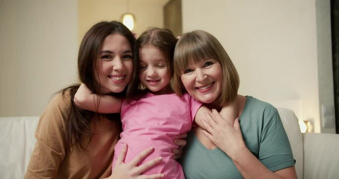 Beautiful granny, mother and daughter are looking at camera and smiling