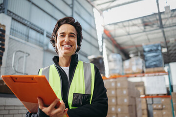 Female logistics manager smiling at the camera in a warehouse