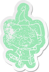 cartoon distressed sticker of a dog wearing santa hat