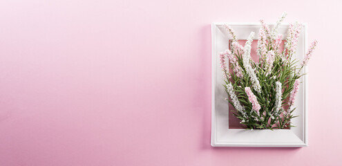 Happy Women's Day decoration concept made from flower and picture frame on pink pastel background.