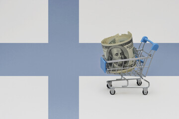 Metal shopping basket with dollar money banknote on the national flag of finland background. consumer basket concept. 3d illustration