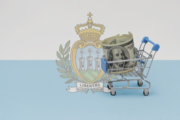 Metal shopping basket with dollar money banknote on the national flag of san marino background. consumer basket concept. 3d illustration