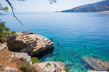 Enjoying the summer sun, jumping  and swimming around on an island beach. An active, adventurous...