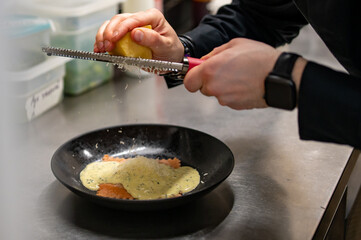 man chef hand cooking one big Ravioli with sauce on restaurant kitchen
