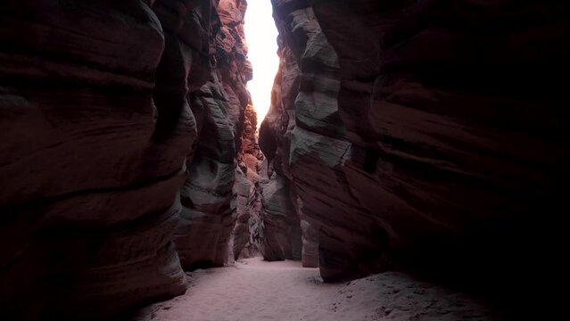 Motion along narrow deep slot canyon with smooth curves red sandstone rocks. Wavy walls of mysterious cave formed by erosion and rainfall. Antelope Canyon is popular place for photos and travel people