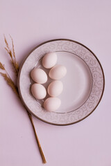 Chicken eggs on a plate. We are preparing for Easter. Beautiful tableware. Eggs on a white background