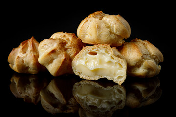 Profitroli cakes on black mirror with reflection