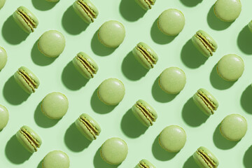 Green pistacio macaroons on green background, colorful french cookies pattern. Gift for 8 March, International Women's Day, Valentine Day