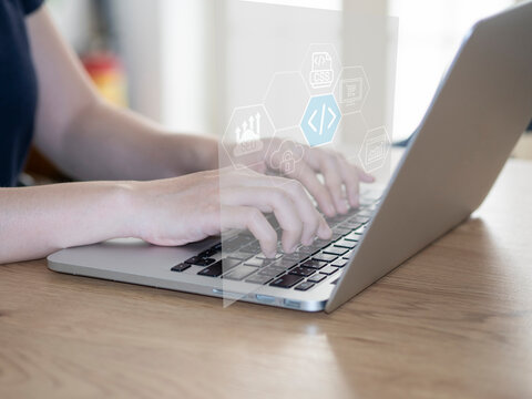 Close-up of a female web developer writing code on a laptop. Illustration of web development work. Business and Technology concept.
