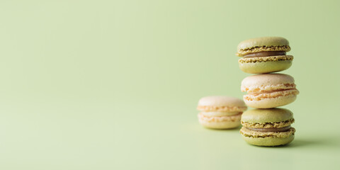 Vanilla and pistacio pastel colored eco handmade macaroons on green background. Gift for 8 March, International Women's Day, Valentine Day