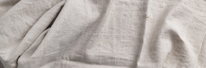 Natural linen fabric texture banner. Flaxen textile background, top view. Rough crumpled burlap...