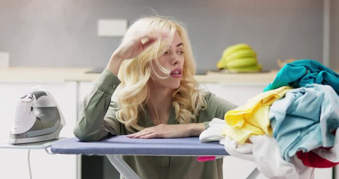 Young Woman Exhausted While Ironing Clothes