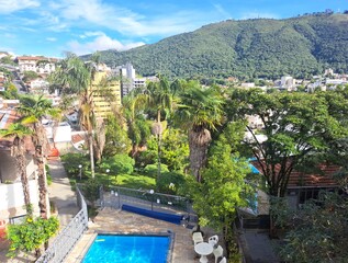 Po&ccedil;os de Caldas, Minas Gerais, Brazil - February 24, 2023. View of the pool at the Hotel in Po&ccedil;os de Caldas with trees and mountain.