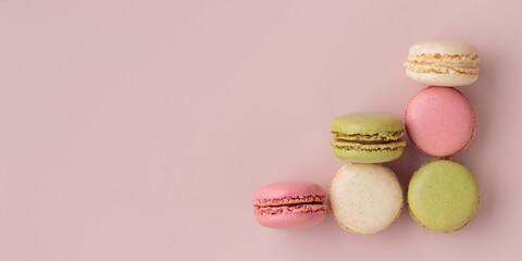 Obraz premium Colorful macaroons on pink background, increase in profits of the confectionery production