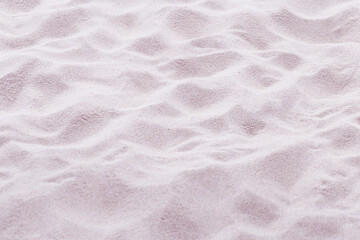 Fototapeta na wymiar Sand texture natural background. Close up waves pattern on sand dunes, beige pink pastel color, minimal nature backdrop, beautiful beach. Summer and travel, spa concept. Selective focus