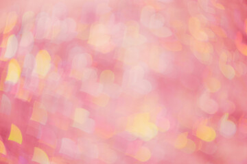 Defocused abstract bokeh background with pink peach pastel colored hearts, flare from lights, monochrome photo, blurred bokeh holiday fon, celebration wallpaper. Glittering aesthetic pattern