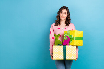 Photo of charming young lady hold packages preparation springtime surprise handmade rabbits easter look copy space isolated on blue color background